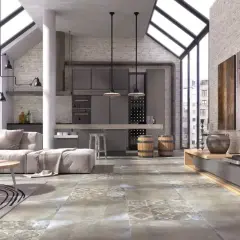 Nowoczesny salon z aneksem kuchennym, gdzie dominują industrialne elementy. Na podłodze pięknie prezentuje się gres szkliwiony o wzorze imitującym beton i kamień.