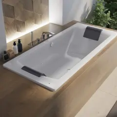 Nowoczesna wanna z baterią na ścianie, otoczona drewnianą zabudową i roślinnością.