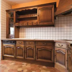 Stara kuchnia z drewnianymi meblami, czekająca na renowację.