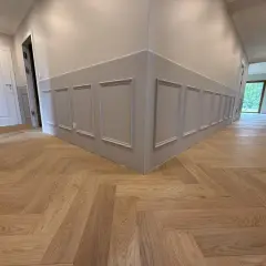 Drewniane podłogi w mieszkaniu inspiracje: jodełka klasyczna na korytarzu, eleganckie panele ścienne.