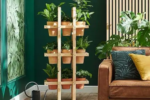 Drewniany stojak na kwiaty diy z doniczkami, idealny do stworzenia zielonego kącika w domu.