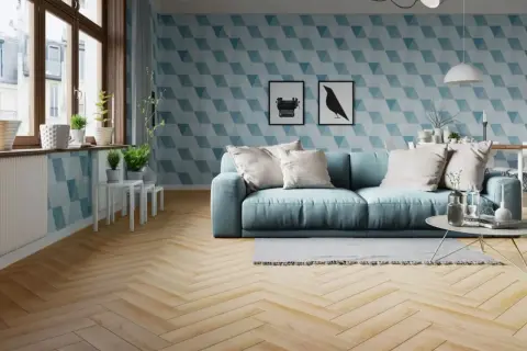Jasny salon z błękitną kanapą i geometryczną tapetą. Podłoga z drewna ułożona w klasyczną jodełkę dodaje elegancji.