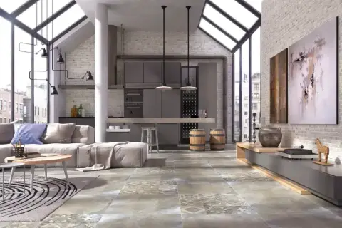 Nowoczesny salon z aneksem kuchennym, gdzie dominują industrialne elementy. Na podłodze pięknie prezentuje się gres szkliwiony o wzorze imitującym beton i kamień.
