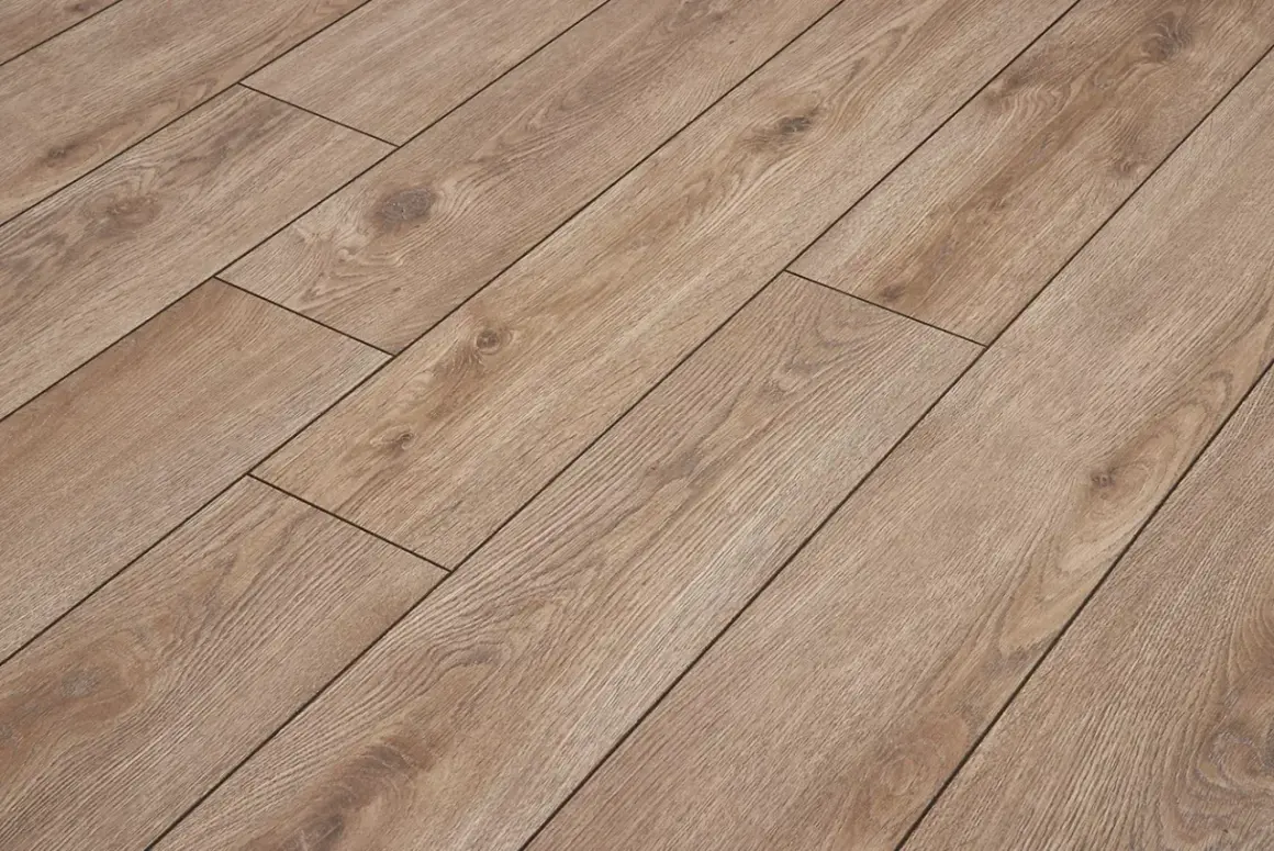 Brązowe panele laminowane z widocznymi słojami drewna ułożone równolegle, tworząc eleganckie wzory układania paneli z fugą.